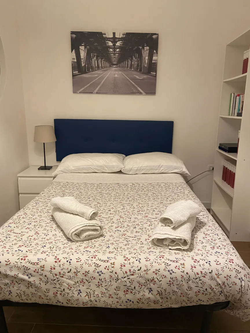 Letto con testata blu e asciugamani