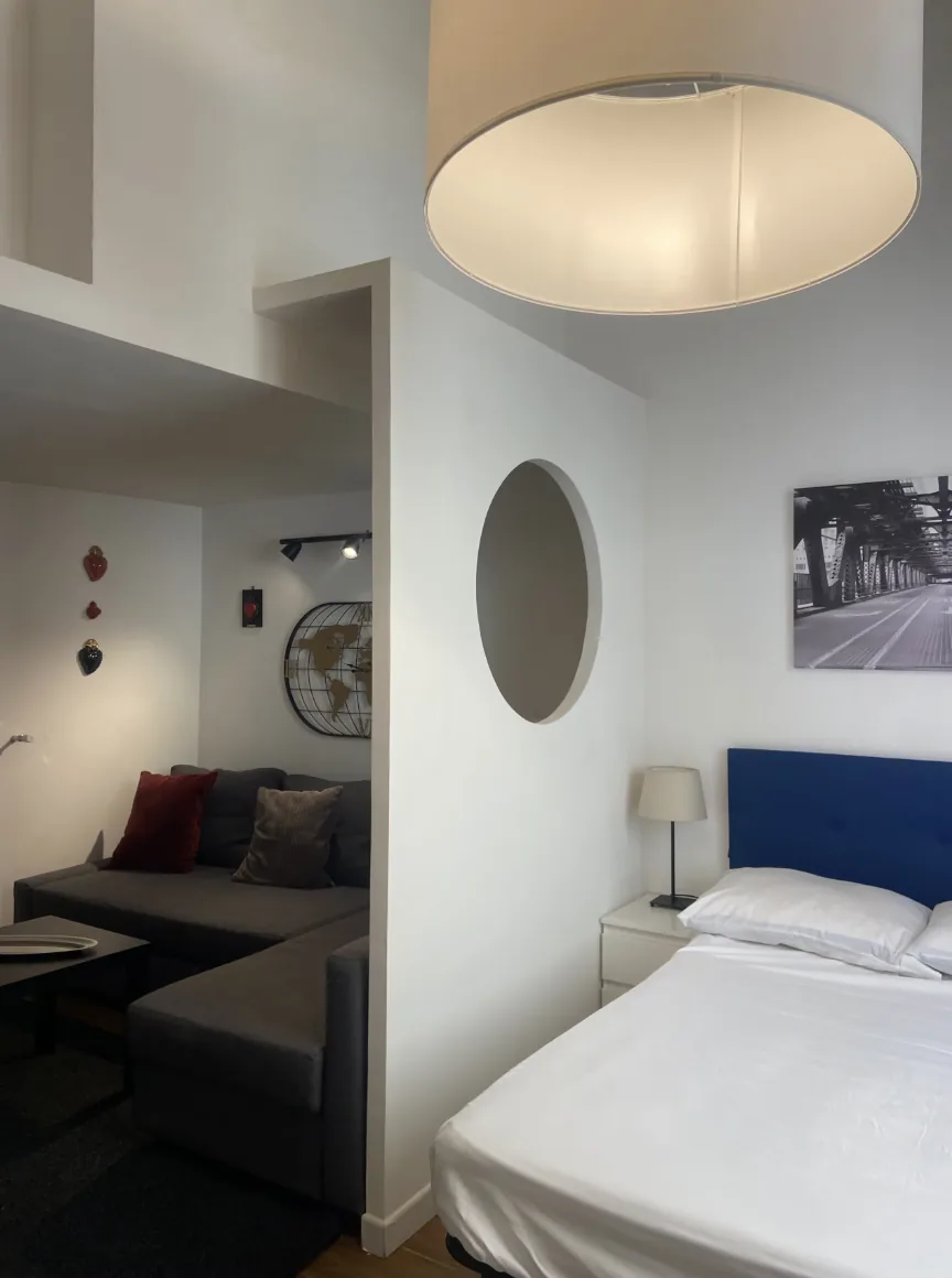 Letto e divano separati dalla parete con apertura circolare