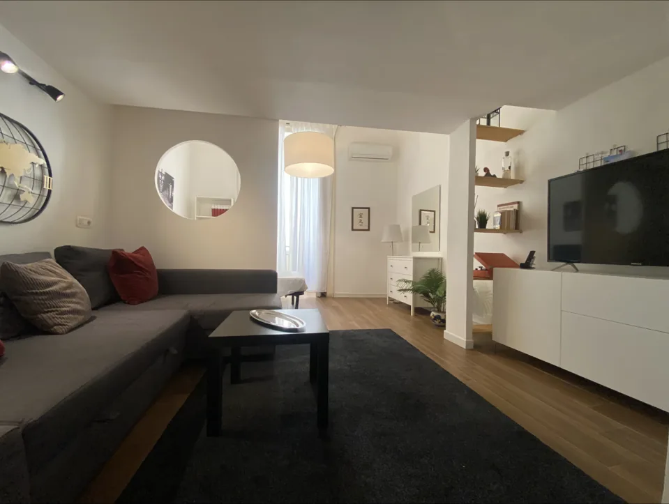 Vista ampia del soggiorno con divano e televisore